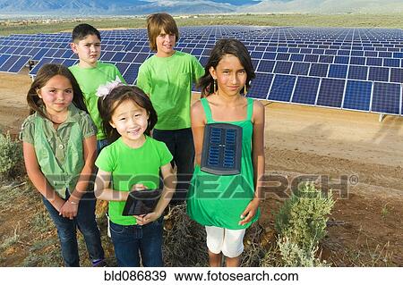 Stock Photo - Children standing together in solar panel field. Fotosearch