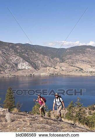 Stock Photo - Couple hiking near remote lake. Fotosearch