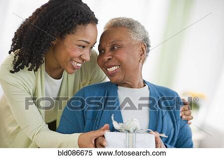 Stock Photography - Daughter giving mother birthday gift. Fotosearch