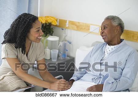 Stock Photo - Daughter visiting mother in hospital. Fotosearch