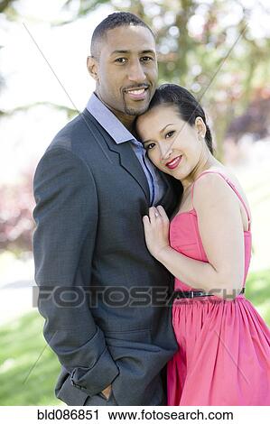 Stock Image - Glamorous couple standing together outdoors. Fotosearch