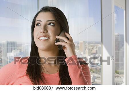 Stock Photo - Hispanic woman talking on cell phone. Fotosearch