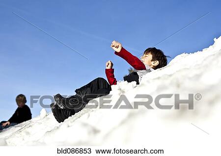 Mixed race boy sledding downhill in snow View Large Photo Image Stock Image - Mixed race boy sledding downhill in snow. Fotosearch