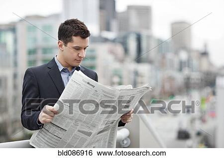 Mixed race businessman reading newspaper View Large Photo Image Stock Photograph - Mixed race businessman reading newspaper. Fotosearch