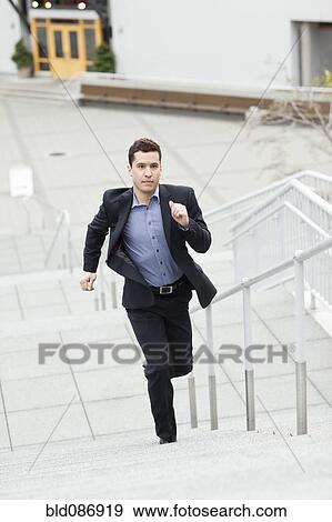 Mixed race businessman running up stairs View Large Photo Image Stock Photo - Mixed race businessman running up stairs. Fotosearch