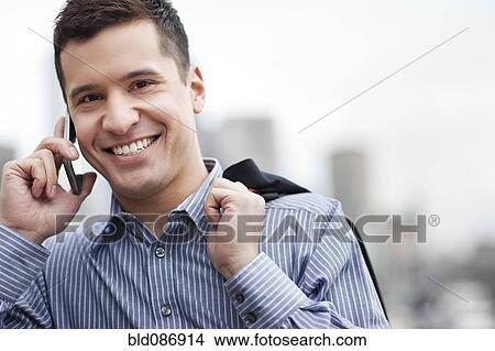 Picture - Mixed race businessman talking on cell phone. Fotosearch