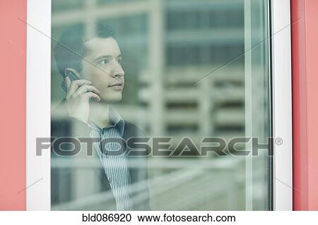 Stock Image - Mixed race businessman talking on cell phone. Fotosearch