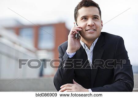 Stock Photo - Mixed race businessman talking on cell phone. Fotosearch