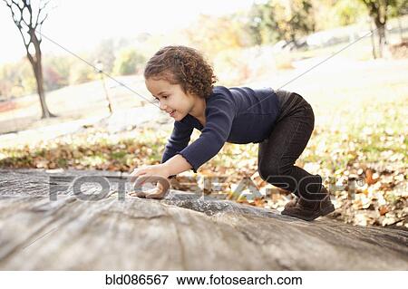Mixed race girl climbing on rock View Large Photo Image Stock Photo - Mixed race girl climbing on rock. Fotosearch