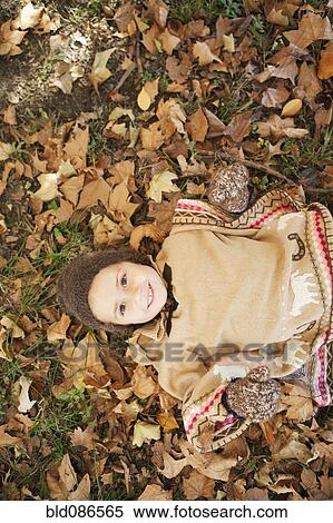 Mixed race girl laying in autumn leaves View Large Photo Image Stock Photography - Mixed race girl laying in autumn leaves. Fotosearch