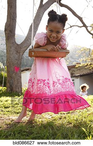Mixed race girl leaning on swing View Large Photo Image Stock Photo - Mixed race girl leaning on swing. Fotosearch