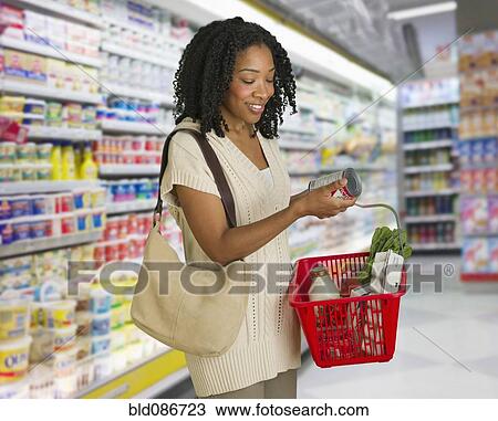 Stock Image - Mixed race woman grocery shopping. Fotosearch
