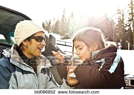 Mother and daughter eating lunch in snow View Large Photo Image Stock Image - Mother and daughter eating lunch in snow. Fotosearch