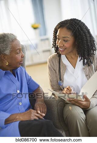 Stock Image - Nurse giving woman checkup. Fotosearch