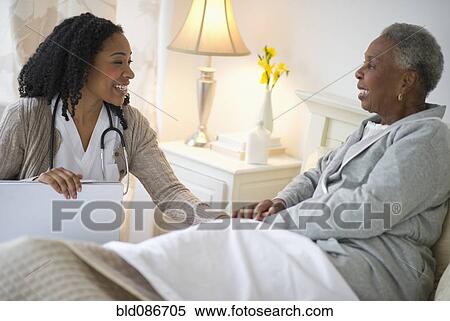 Stock Photography - Nurse giving woman checkup. Fotosearch