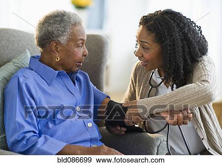 Nurse taking woman's blood pressure View Large Photo Image Stock Photo - Nurse taking woman's blood pressure. Fotosearch