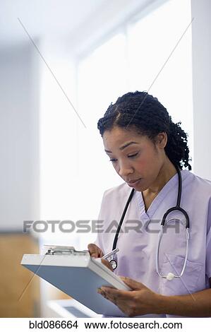 Picture - Nurse writing in medical record in hospital. Fotosearch