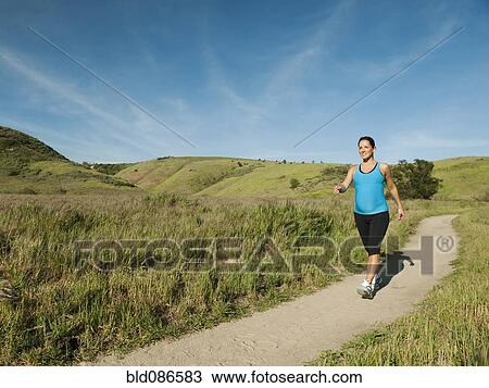 Stock Image - Pregnant Hispanic woman running in remote area. Fotosearch