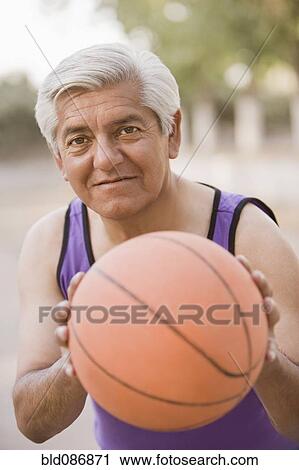 Stock Image - Senior Chilean man playing basketball. Fotosearch
