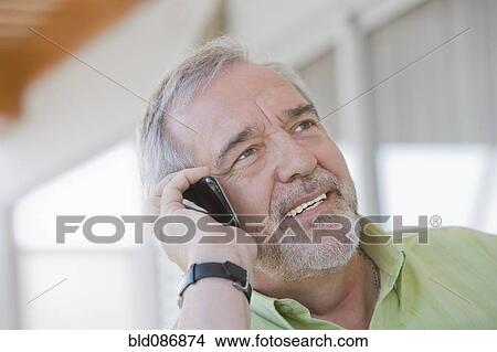 Picture - Senior Chilean man talking on cell phone. Fotosearch