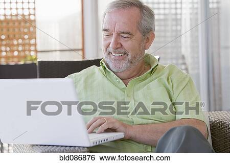 Senior Chilean man typing on laptop View Large Photo Image Stock Photograph - Senior Chilean man typing on laptop. Fotosearch