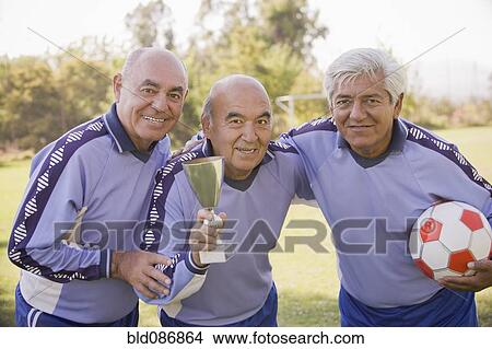 Picture - Senior Chilean soccer players holding trophy and soccer ball. Fotosearch