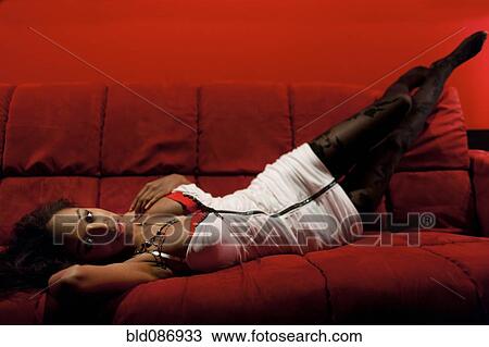 Stock Image - Sexy African American woman laying on sofa. Fotosearch