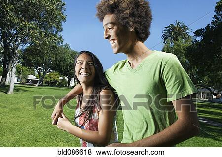 Stock Photo - Teenage couple walking in park. Fotosearch