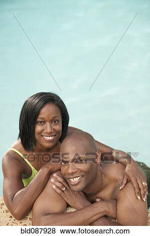 African American couple leaning on edge of swimming pool View Large Photo Image Stock Photo - African American couple leaning on edge of swimming pool. Fotosearch
