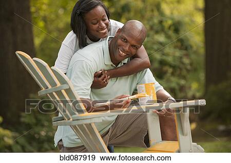 African American couple painting chair in backyard View Large Photo Image Stock Photo - African American couple painting chair in backyard. Fotosearch
