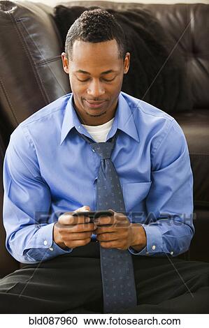 Black businessman text messaging on cell phone View Large Photo Image Stock Image - Black businessman text messaging on cell phone. Fotosearch