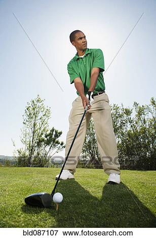 Stock Photo - Black golfer preparing to swing golf club. Fotosearch