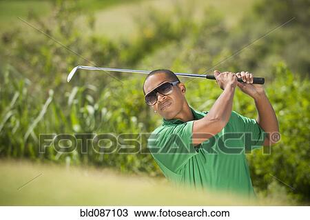 Black golfer swinging golf club View Large Photo Image Stock Image - Black golfer swinging golf club. Fotosearch