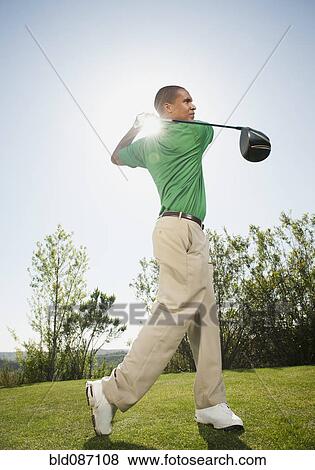 Black golfer swinging golf club View Large Photo Image Stock Photo - Black golfer swinging golf club. Fotosearch