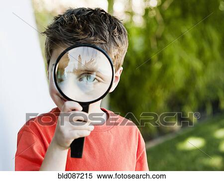 Stock Photography - Caucasian boy looking through magnifying glass. Fotosearch