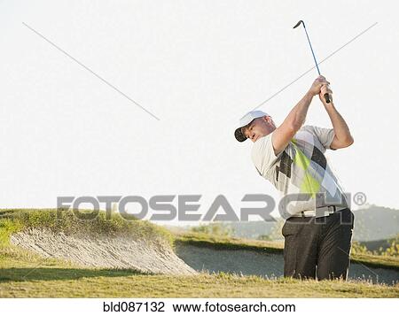 Caucasian golfer hitting ball out of bunker View Large Photo Image Stock Image - Caucasian golfer hitting ball out of bunker. Fotosearch