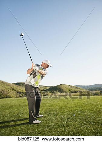 Stock Photography - Caucasian golfer preparing to swing golf club. Fotosearch