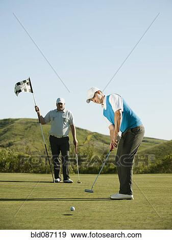 Caucasian golfer putting on golf course View Large Photo Image Stock Photo - Caucasian golfer putting on golf course. Fotosearch