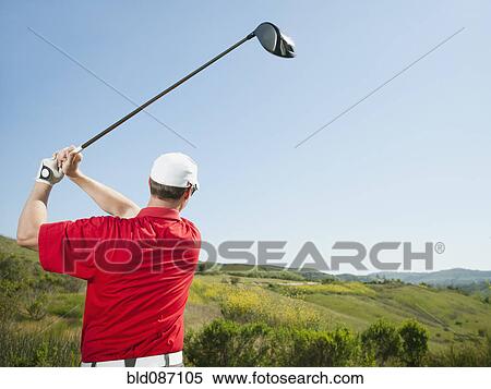 Stock Photography - Caucasian golfer swinging golf club. Fotosearch