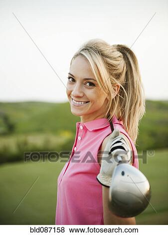 Stock Photo - Caucasian woman holding golf club. Fotosearch
