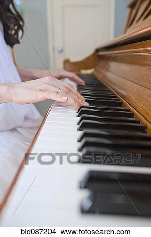 Picture - Close up of mixed race woman playing piano. Fotosearch