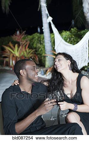 Couple drinking red wine together at night View Large Photo Image Picture - Couple drinking red wine together at night. Fotosearch