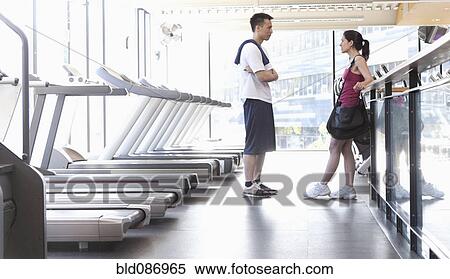 Stock Photography - Couple talking together in health club. Fotosearch