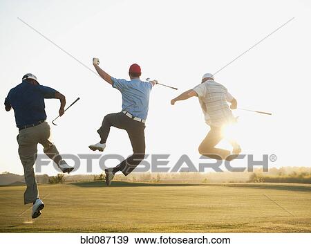 Stock Photo - Excited golfers jumping in mid-air on golf course. Fotosearch