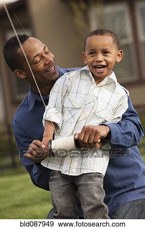 Stock Photo - Father and son flying kite. Fotosearch
