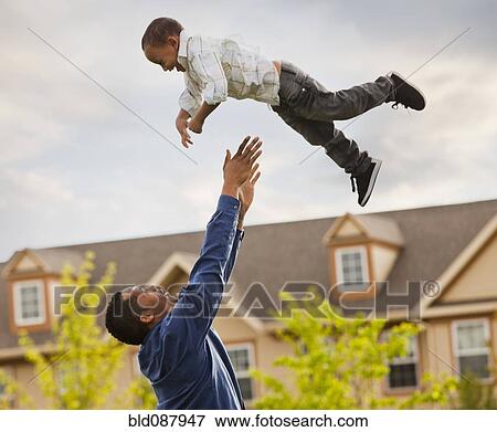 Stock Photo - Father throwing son into the air. Fotosearch