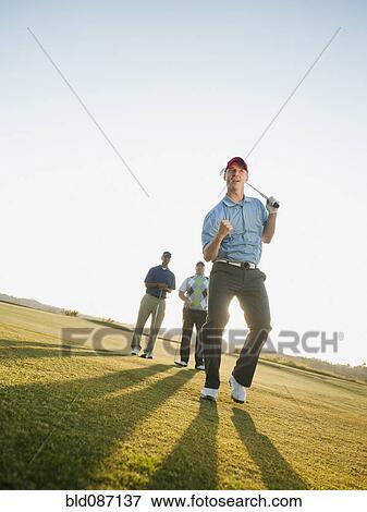 Friends watching golfer cheering View Large Photo Image Stock Photo - Friends watching golfer cheering. Fotosearch