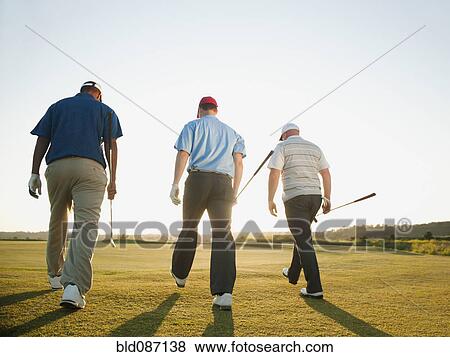 Stock Photo - Golfers walking together on golf course. Fotosearch