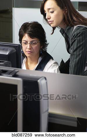 Stock Photo - Hispanic businesswoman working together in office. Fotosearch