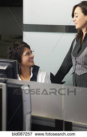Stock Photo - Hispanic businesswomen working together in office. Fotosearch